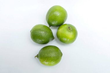 Four whole lemons on a white background, with a top angle, placed next to each other, with the fruit on the right showing its top and the others lying down