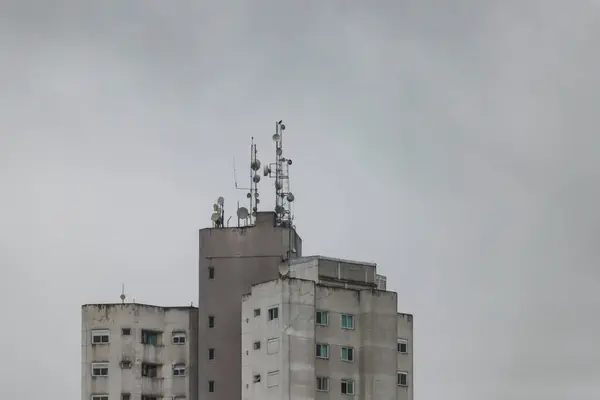 Parte Superior Edificio Gris Destacando Sus Antenas Día Nublado —  Fotos de Stock