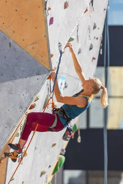 Genç kız yapay bir duvara tırmanmakla meşgul. Spor ve sağlık.
