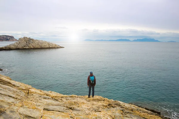 Sırt çantalı kız deniz kıyısındaki bir dağda duruyor. Gezgin, dağda durarak denize bakıyor. Türkiye 'ye gitmek. özgürlük ve mutluluk.