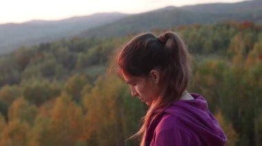 Kız gün batımında yürüyüş sırasında manzaranın fotoğrafını çeker..