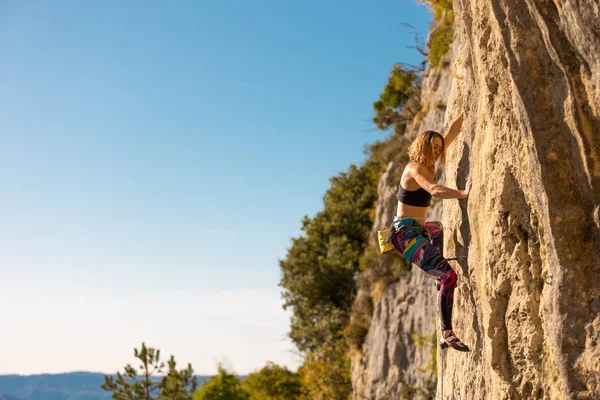 少女は岩に登る 登山列車は自然の地形を利用している 青い空を背景に困難な登山ルートを克服する女性 クロアチアのロッククライミング Kompanj — ストック写真