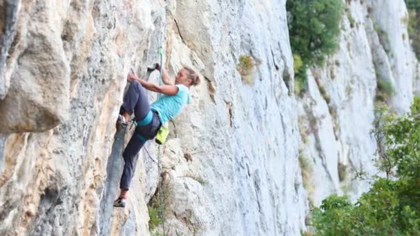 Das Mädchen erklimmt den Felsen. — Stockvideo