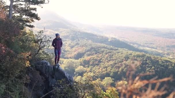 Dziewczyna stoi na krawędzi klifu i patrzy w oddali. — Wideo stockowe