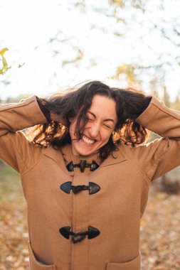 Güzel kız yürürken kırışıyor ve gülümsüyor. Samimi neşe ve eğlence duyguları.