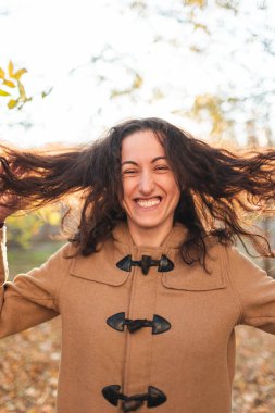 Güzel kız yürürken kırışıyor ve gülümsüyor. Samimi neşe ve eğlence duyguları.