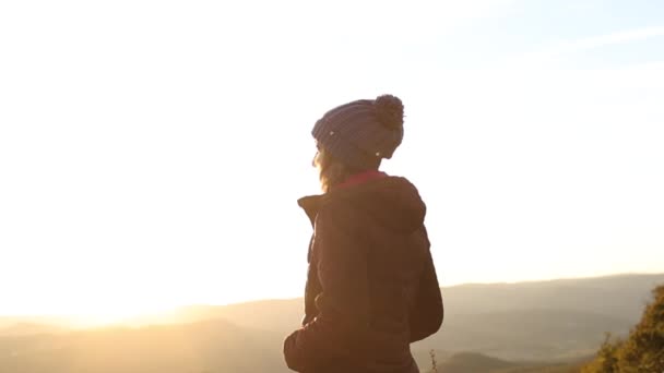 La fille se tient sur le bord de la falaise et regarde dans la distance. — Video