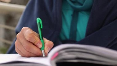 Kadın elleri ve yakın plan bir kalem.