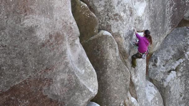 Schönes Mädchen erklettert den Felsen. — Stockvideo