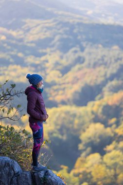 Bir kadın gün batımını güzel bir yerde karşılar, kız seyahat ederken dağdan güzel bir manzaranın tadını çıkarır.