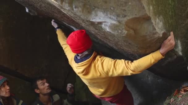 En fjellklatrer klatrer på en steinblokk i det fri. – stockvideo