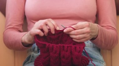 Kadın yün iplikten şapka örüyor.. 