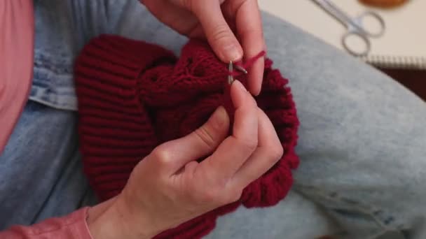 Женщина вяжет шляпу из шерстяной пряжи. — стоковое видео