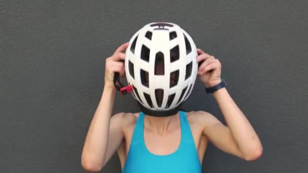 Retrato de una chica sonriente que se pone un casco de bicicleta. — Vídeos de Stock