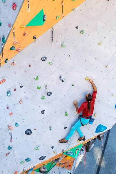 登山の壁を登る男 登山家は人工地形の訓練です 街でロッククライミング 強い男 街のスポーツ 極端なスポーツの安全性 — ストック写真