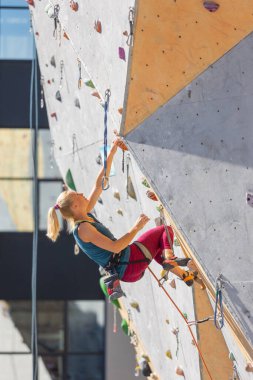 Genç kız yapay bir duvara tırmanmakla meşgul. Spor ve sağlık.