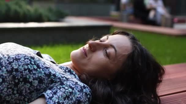 Une belle femme en robe longue se repose dans le parc — Video