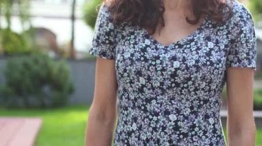 Uzun kıvırcık saçlı, gülümseyen bir kadın. 