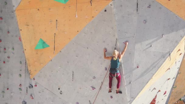 Vacker flicka klättrar klätterväggen — Stockvideo