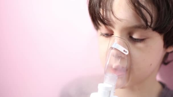 The child does inhalation, the boy inhales the medicine through the mask — Stockvideo