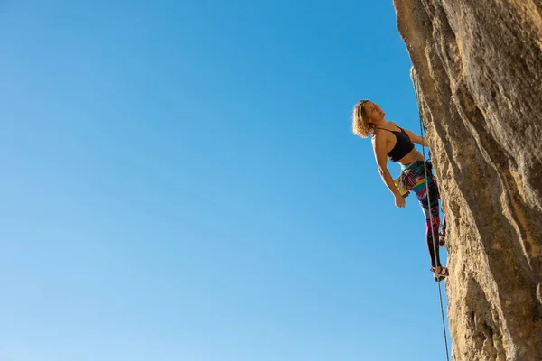 少女は岩に登る 登山列車は自然の地形を利用している 青い空を背景に困難な登山ルートを克服する女性 クロアチアのロッククライミング Kompanj — ストック写真