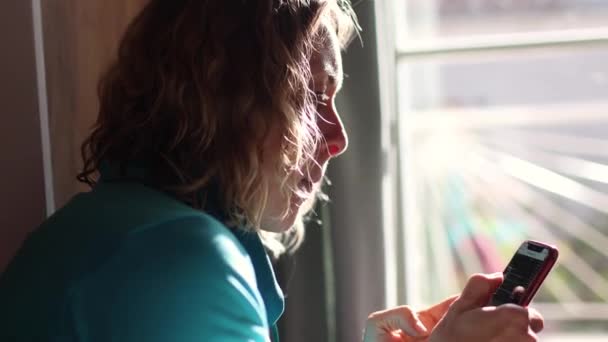 Menina come e verifica mensagens em um smartphone — Vídeo de Stock