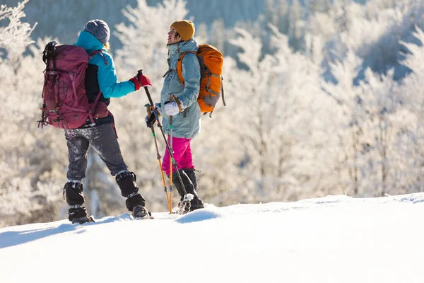 两名妇女穿着雪鞋在雪地里行走 冬季徒步旅行 两名男子穿着登山装备在山上行走 — 图库照片