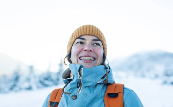 笑着的女人 牙齿上戴着牙套 在冬天的群山和白雪覆盖的树木的背景下描绘着一个女孩 — 图库照片