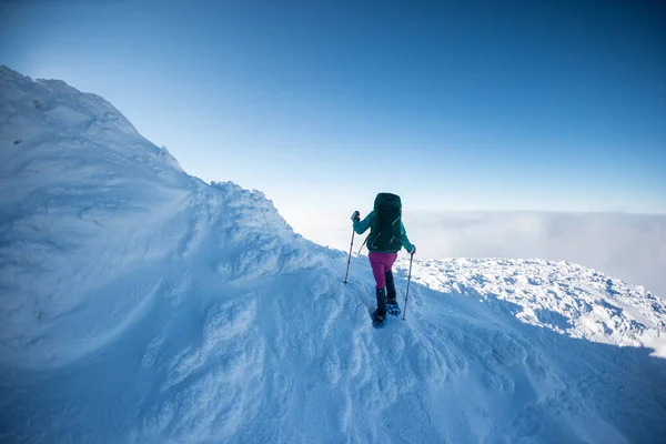 Μια Γυναίκα Σακίδιο Χιονοπέδιλα Σκαρφαλώνει Ένα Χιονισμένο Βουνό Χειμερινή Πεζοπορία — Φωτογραφία Αρχείου
