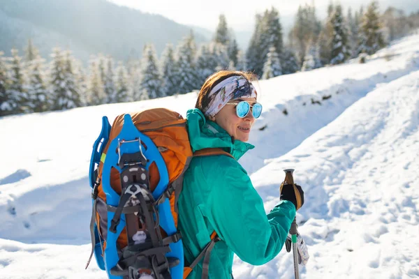 一个女人背着雪鞋走路 冬天徒步旅行 冬天爬山 带着远足装备 — 图库照片