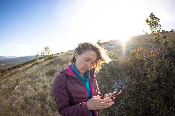 Woman Stands Top Mountain Looks Smartphone Girl Uses Navigator Find — Zdjęcie stockowe