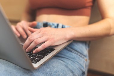 Kadın elleri klavyede, kız dizüstü bilgisayarda çalışıyor ve yazıyor, serbest çalışan evde çalışıyor, kadın parmakları tuşlara basıyor.