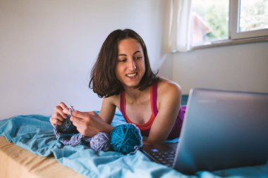 Bir kadın örgü örüyor, satılık örüyor, internette örgü örmeyi öğreniyor, dikiş dersleri, dizüstü bilgisayar ve ev hobileri izleyen bir kız..