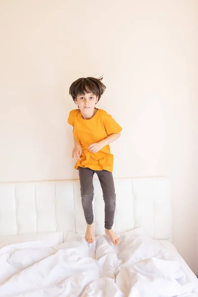 Niño Enérgico Está Saltando Cama Niño Pijama Está Jugando Habitación —  Fotos de Stock