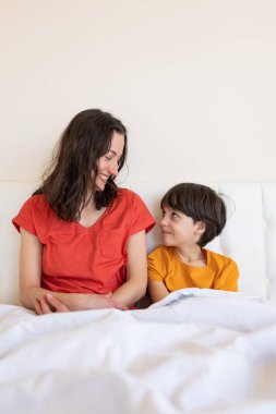Annesiyle birlikte bir çocuk, pijamalı bir kadın ve bir çocuk, bir kadın sabah annesiyle birlikte oğluna sarılıyor.