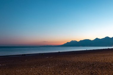 Gün batımında deniz ve dağlar, okyanus dalgaları, okyanusta akşam.