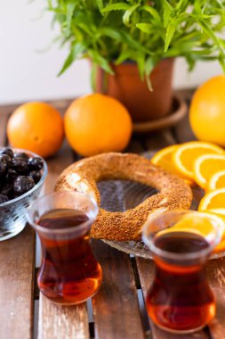 Türk kahvaltısı, Türk çayı, portakal ve zeytin, susamlı simit ve ahşap masa üzerinde saksı bitkisi