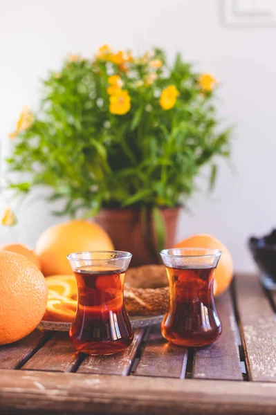 Turkish breakfast, turkish tea, oranges, sesame bagel and potted plant on wooden table