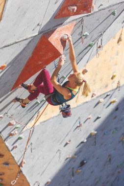 Genç kız yapay bir duvara tırmanmakla meşgul. Spor ve sağlık.