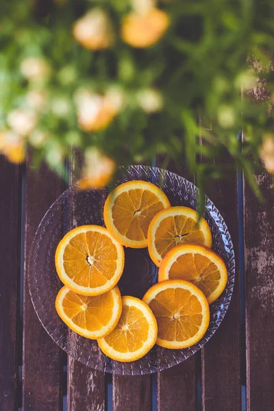 Prato Com Laranjas Vaso Plantas Uma Mesa Madeira Fatias Cítricas — Fotografia de Stock