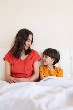 Annesiyle birlikte bir çocuk, pijamalı bir kadın ve bir çocuk, bir kadın sabah annesiyle birlikte oğluna sarılıyor.