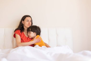 Annesiyle birlikte bir çocuk, pijamalı bir kadın ve bir çocuk, bir kadın sabah annesiyle birlikte oğluna sarılıyor.