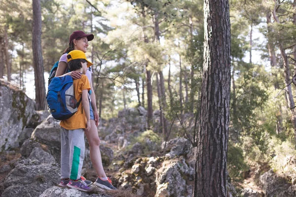 Bir kadın ve çocuğu dağ yolunda yürür, sırt çantalı bir çocuk annesiyle seyahat eder, çocuklarla yürüyüşe çıkar, çocuk ormanda yürür, aktif bir yaz tatili geçirir..