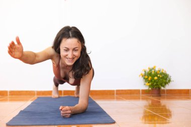 Kadın evde yoga yapıyor, zayıf kız egzersiz yapıyor, esneme egzersizleri yapıyor karın kası egzersizi yapıyor, karın kası egzersizi yapıyor.