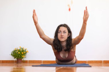 Kadın evde yoga yapıyor, zayıf kız egzersiz yapıyor, esneme egzersizleri yapıyor.