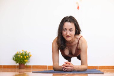 Kadın evde yoga yapıyor, zayıf kız egzersiz yapıyor, esneme egzersizleri yapıyor karın kası egzersizi yapıyor, karın kası egzersizi yapıyor.