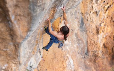 a strong man climbs a difficult climbing route. rock climbing as an olympic sport. outdoor workout.