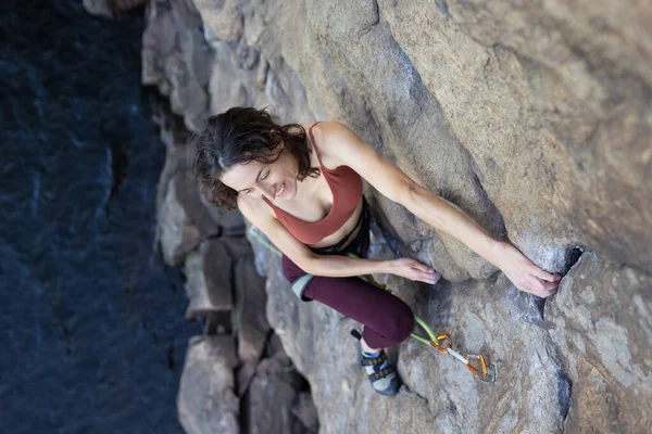 美丽的女孩爬上水面上的岩石 攀爬大自然的运动 极限运动 健康与美丽 — 图库照片