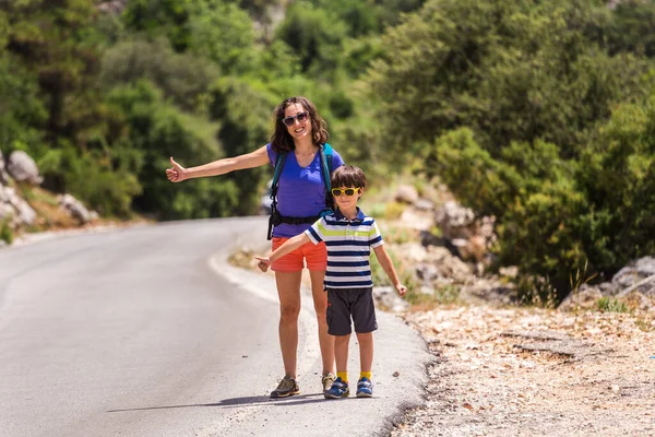 A woman with a child stop the car on the road, a hitchhiker with children, a boy with a mother hitchhike, travel through picturesque places