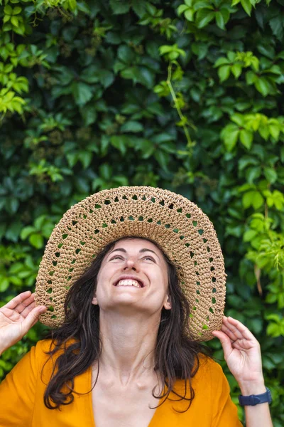 Uśmiechnięta Dziewczyna Słomkowym Kapeluszu Stoi Obok Ściany Porośniętej Bluszczem Portret — Zdjęcie stockowe
